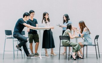 two men and four women meeting in office